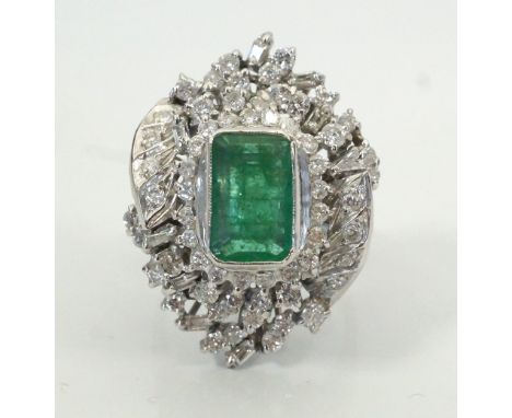 IMPRESSIVE EMERALD AND DIAMOND DRESS RINGthe central emerald approximately 3cts in ornate baguette and round cut diamond surr