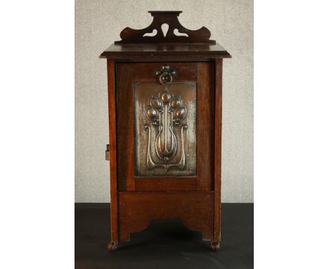 An Arts &amp; Crafts oak coal purdonium, with a pierced gallery back over a silvered copper panel decorated with stylised flo