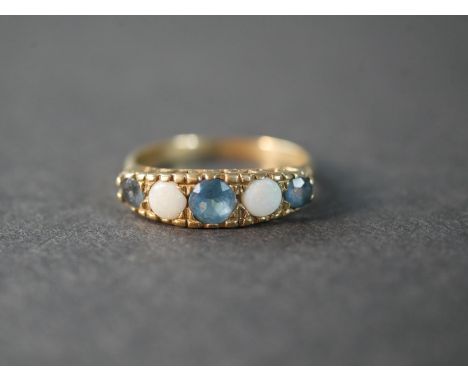 A 9 carat gold blue topaz and opal five stone ring, set with two round cabochon opals with a combined approximate weight of 0