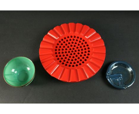 A green translucent glass bowl with brass detailing, along with a vintage blue enamel geometric design ashtray and a red acry
