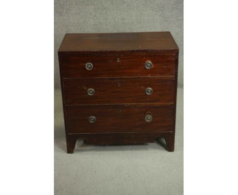 A George III mahogany chest of three long drawers with brass ring handles over a shaped apron and bracket feet . H.78 W.79 D.