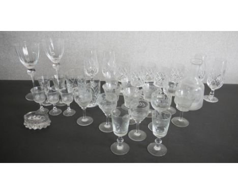 A collection of drinking glasses, including a set of five hand cut crystal tumblers, two wine glasses an etched decanter and 