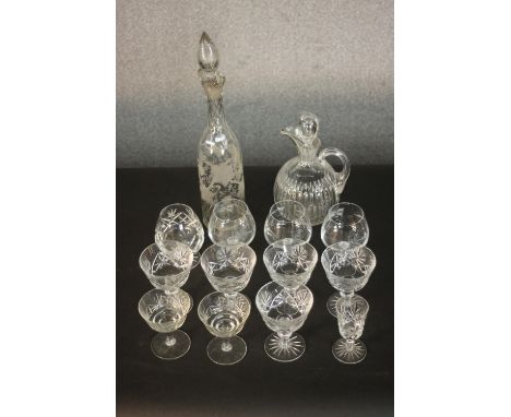 A collection of twelve crystal and glass drinking glasses along with an etched vine design decanter and oil bottle with stopp