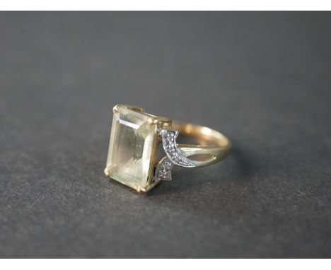 A 9 carat topaz and diamond dress ring, set to centre with a rectangular emerald cut topaz with an approximate weight of 7.73