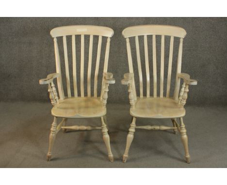 A pair of late 20th century oak Windsor carver chairs, with a comb back above a shaped seat on turned legs joined by H stretc