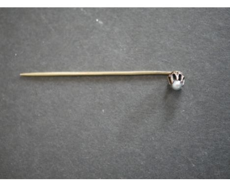 A yellow metal and cultured pearl stick pin in an antique leather box. 