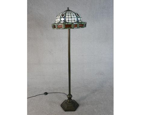 A Tiffany style standard lamp, with a stained glass shade, on a bronzed metal stem with a hexagonal base. H.456 W.46cm 