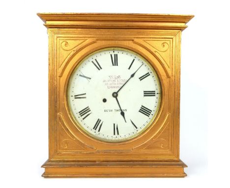 An early 20th century Seth Thomas hanging wall clock, in a gold painted wooden square case, with detailed decoration, the whi