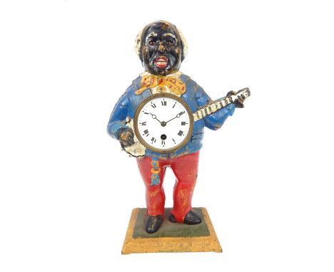 An early 20th century clock in the form of an American 'Blackman' playing the banjo, wearing brightly coloured clothing, the 