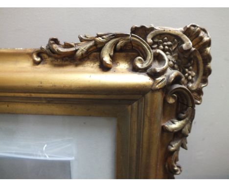 AN ANTIQUE GILT PICTURE FRAME, with moulded and carved scrolling detail to corners, having inset modern print, glazed, rebate