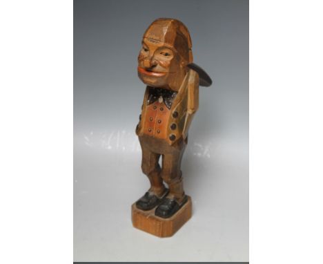 A CARVED BLACK FOREST NOVELTY NUT CRACKER IN THE FORM OF A MAN, stood with his hands in his pockets, painted with coloured hi