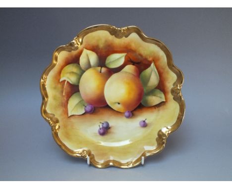 A COALPORT HAND PAINTED PORCELAIN CABINET PLATE, decorated with fruit to a mossy background by K Davenport, with shaped gilt 