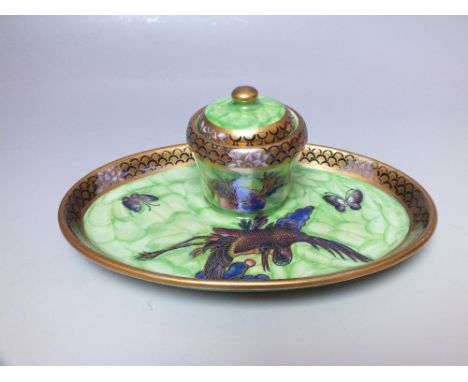 AN OVAL MALING LUSTRE LIDDED INKWELL, the tray mounted with a single inkwell having ceramic liner, the cover with button fini