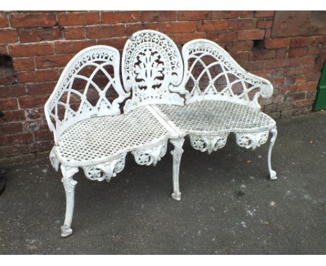 A WHITE PAINTED CAST METAL GARDEN BENCH, of shaped trefoil design, with a pierced lattice work seat, raised on shaped support