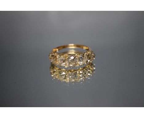 AN 18 CARAT YELLOW GOLD GRADUATING DIAMOND HALF ETERNITY RING, set with five old cut diamonds, the centre stone having an ind