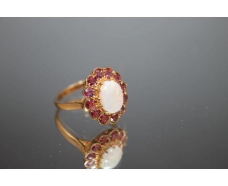 A HALLMARKED 9 CARAT GOLD OPAL RING,  surrounded by twelve dark pink stones, ring size N