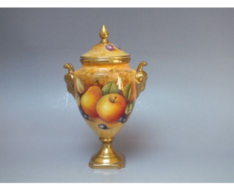 A COALPORT HAND PAINTED PORCELAIN TWIN HANDLED URN AND COVER, decorated with fruit to a mossy background by Norman Lear, the 