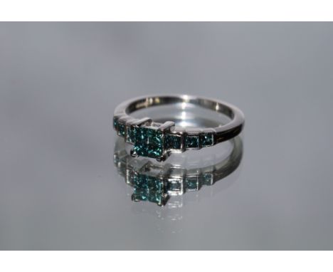 A HALLMARKED K WHITE GOLD BLUE DIAMOND RING, set with graduating princess cut diamonds and coming with certificate stating st