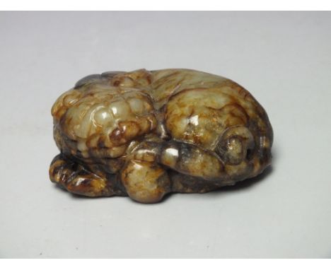 AN EARLY CHINESE RUSSET AND GREEN JADE CARVING OF A BUDDHIST LION, L 6 cm Note: Origin or treatments of this jade item unknow
