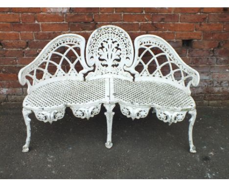 A WHITE PAINTED CAST METAL GARDEN BENCH, of shaped trefoil design, with a pierced lattice work seat, raised on shaped support