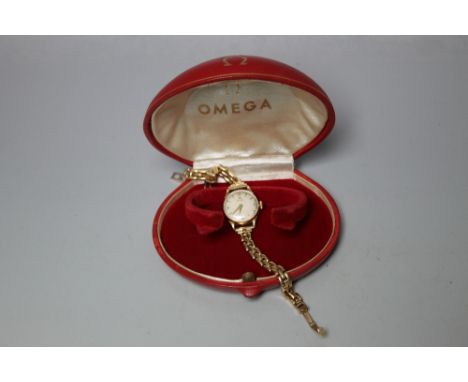 A LADIES 9 CARAT GOLD OMEGA WRIST WATCH, having circular champagne dial, Arabic quarter hour markers, arrow head hour markers