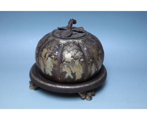 AN UNUSUAL ORIENTAL STYLE LOBED JAR AND COVER ON STAND, the painted metal jar decorated with Oriental fighting figures in typ
