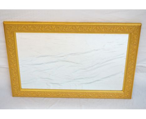 GILT FRAMED RECTANGULAR BEVELLED WALL MIRROR
the frame with raised floral decoration, with hook attachments for portrait or l