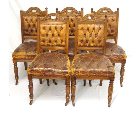 SET OF FIVE VICTORIAN OAK DINING CHAIRS 
with shaped leather button backs below finial decoration, and with stuffover leather