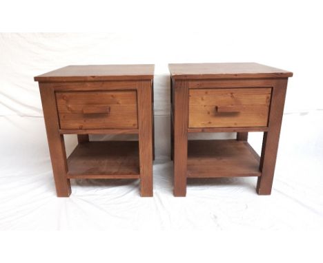 PAIR OF STAINED PINE BEDSIDE TABLES
with square tops above a single drawer with a shelf below, standing on block supports, 60