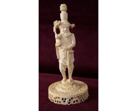 CHINESE CARVED IVORY FIGURAL STAND
of a sage standing with his staff and holding a plant with four blooms, standing on elabor