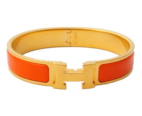 HERMES 'CLIC H' ORANGE ENAMEL DECORATED GOLD PLATED BRACELET
with central 'H' motif, with Hermes pouch