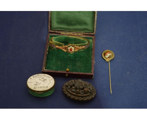 A Victorian gilt bangle inset red and clear paste stones (cased); a 19th Century enamel pill box 'A trifle from Ipswich'; a y