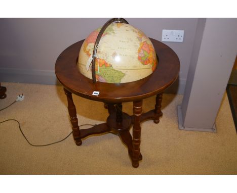 A globe on turned mahogany stand, with electric light fitting.