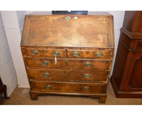 A George III oak bureau, with fall flap opening to reveal pigeon holes and drawers, above two short and three long drawers, r