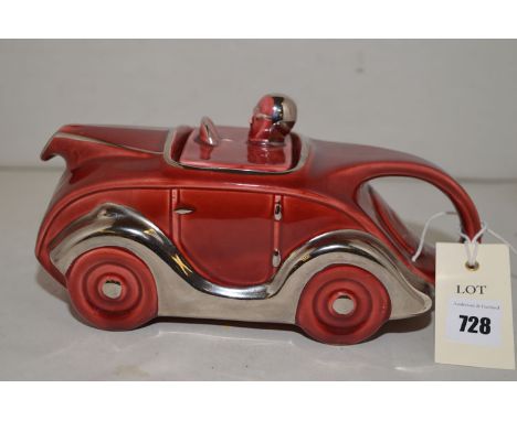 A Sadler teapot in the form of a racing car and man, with red glaze and silver gilt, no. 820236.