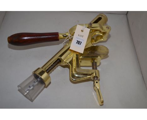 A brass bench mounting commercial corkscrew with turned wooden handle.