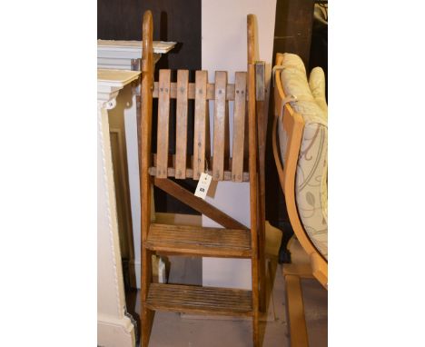 A folding three-tread wooden step ladder.