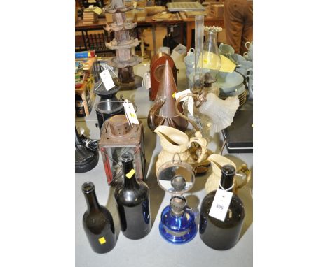 A black painted railway lamp; a lantern; two copper grain scoops; three green glass wine bottles; pressed glass oil lamps; an