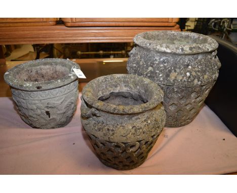 Two composite stone garden urns, with lattice decoration to sides, various sizes; together with another with lion mask decora