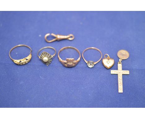 A 9ct. yellow gold crucifix pendant, 3.3grms; a three stone diamond ring on yellow metal mount, stamped '9ct.'; three other r