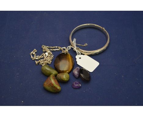 A silver bangle with engraved decoration, Birmingham; a tiger's eye pendant on yellow metal chain; a smoky quartz cut stone; 