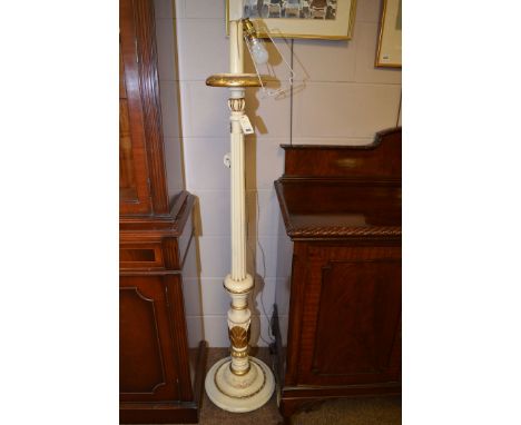 A gold coloured and white painted standard lamp white silk shade with tassels.