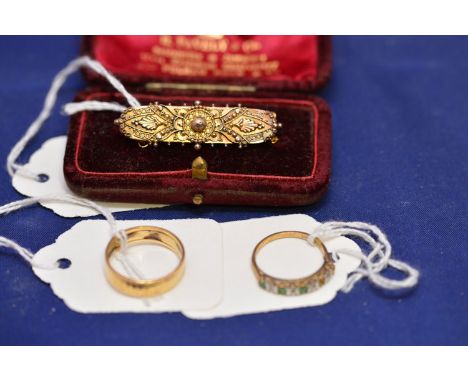 A Victorian yellow metal etruscan style brooch, stamped '15ct', cased; an 18ct. yellow gold wedding band, 4grms; and an emera