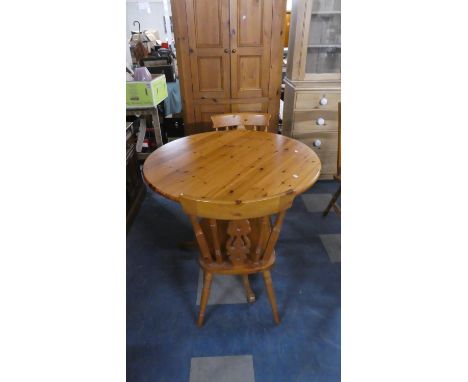 A Circular Pine Kitchen Table and Two Spindle Back Chairs 