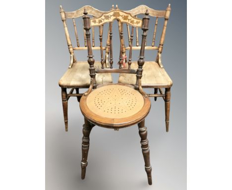 A pair of poker work spindle back chairs and a similar chair.