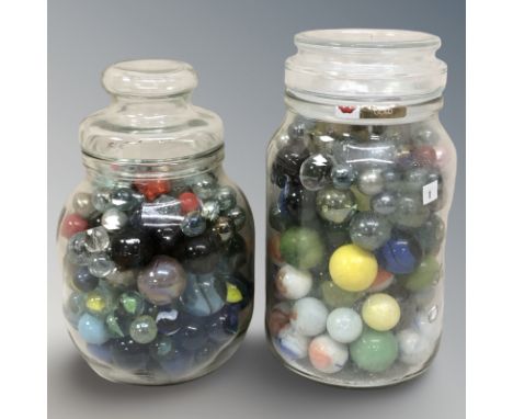 Two glass jars containing assorted marbles.