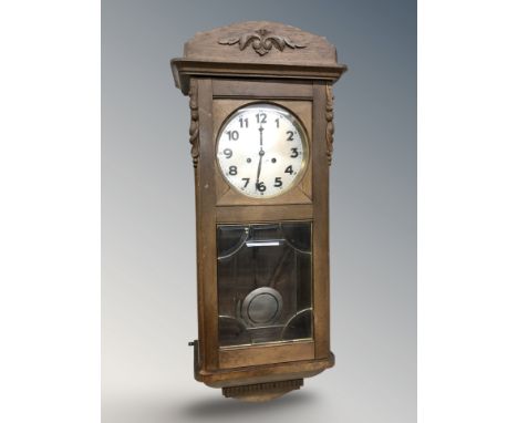 A Junghans carved oak eight day wall clock with silvered dial, length 83 cm.