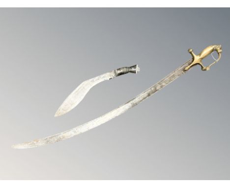 An Indian talwar with brass lion's head pommel, length 90 cm, together with a kukri. 