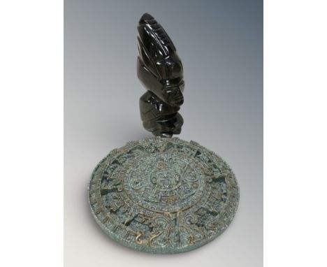 A carved golden obsidian Aztec style figurine and a reproduction Aztec calendar plaque, diameter 18 cm.