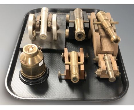 Four brass miniature model cannons on carriages, a further similar example and a miniature churn.